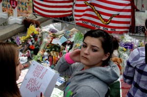 A woman holds back her emotions while visiting a makeshift memorial on Boylston Street several blocks east of the bombing sites in Boston, Massachusetts, on Thursday, April 18, 2013. (KEITH MACKENZIE PHOTO)